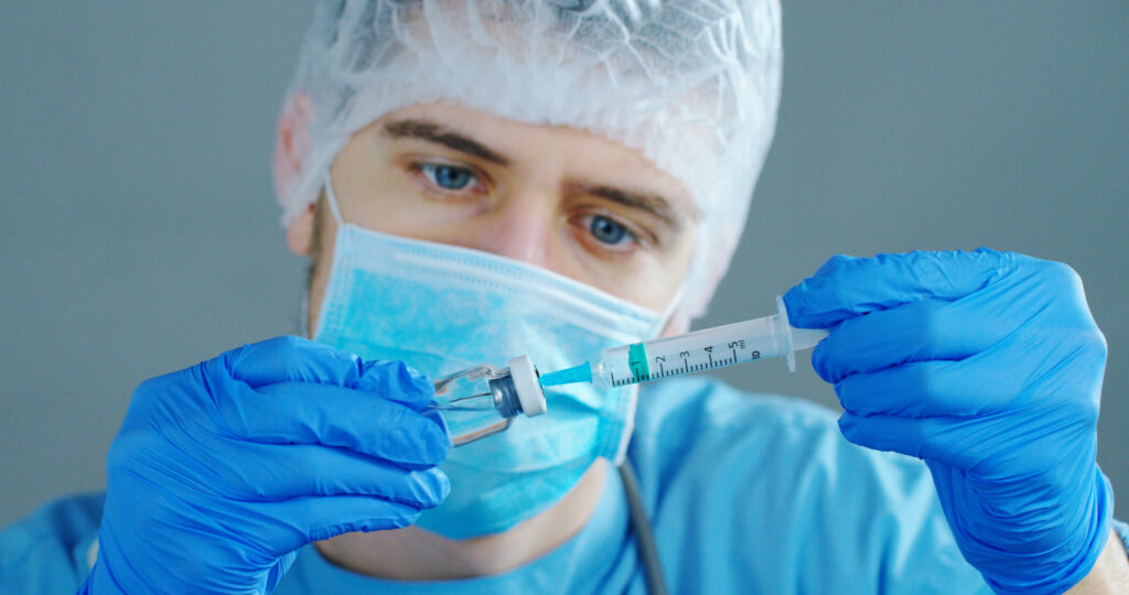 a,doctor,or,scientist,in,laboratory,holding,a,syringe,with